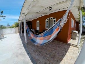 a hammock hanging off the side of a house at Refúgio da Ilha in Ilha Comprida