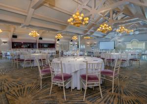 a banquet hall with white tables and chairs and chandeliers at Treacys Oakwood Hotel, Shannon in Shannon