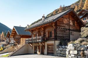 a large wooden house with a balcony on a mountain at Chalet Veyrier, 900m du pied des pistes de ski in Abriès