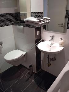 a white bathroom with a toilet and a sink at Fischeln schönes Apartment in Krefeld