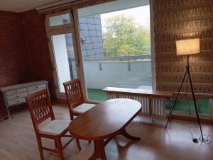 a room with a table and two chairs and a lamp at Fischeln schönes Apartment in Krefeld