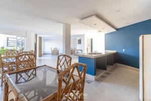 a kitchen and dining room with chairs and a blue wall at Vista Mar em Búzios Praia de Geribá c/ Piscina in Búzios