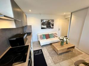 a small living room with a couch in a kitchen at appartement Riorges 35 m2 1 chambre in Riorges
