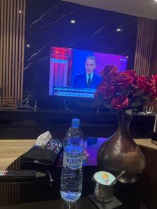 a bottle of water sitting on a table with a television at Ronza in Abidjan