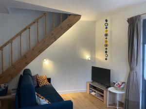 ソミュールにあるChez Juliette - Maison et jardin - bord de Loire à Saumurの青いソファと階段のあるリビングルーム