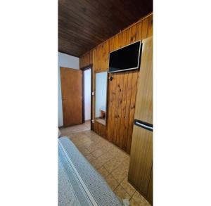 a living room with a television and a hallway at Kitnet perto da rodoviária Campos do Jordão in Campos do Jordão +29 photos