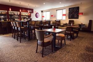 un restaurante con mesas y sillas y un bar en Douglas Arms Hotel en Banchory