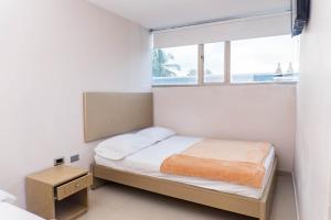 ein kleines Schlafzimmer mit einem Bett und einem Fenster in der Unterkunft HOTEL DASANTO HD in Barranquilla + 30 Fotos