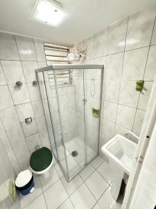 Un baño con ducha, inodoro y lavabo. en Pé na Areia Canto do Forte, en Praia Grande