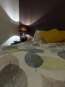 a bedroom with a bed with a colorful comforter at Cosy 1-Bed Studio City Centre in Kidderminster