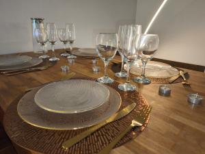 a table with plates and wine glasses on a wooden table at T2 Moderne Centre Ville in Le Havre