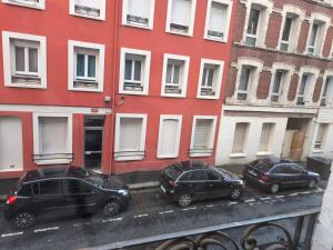 three cars parked in front of a red building at T2 Moderne Centre Ville in Le Havre