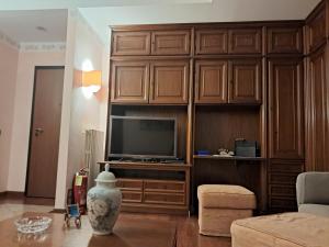una sala de estar con un gran centro de entretenimiento de madera con TV en Roses house, en Porto San Giorgio
