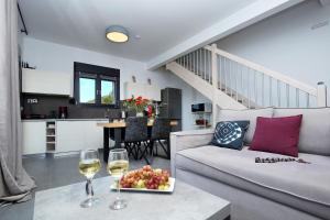 a living room with a couch and two glasses of wine at Point of View Cassiopeia in Drymon
