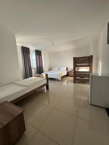 a large white room with two beds and a chair at Hotel Palace Struga in Struga