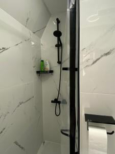 a bathroom with a shower with white marble walls at Amsterdam Soul Inn in Amsterdam
