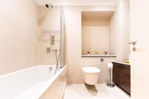 a bathroom with a toilet and a tub and a sink at Bright & Modern One Bedroom Flat in Farringdon in London +27 photos