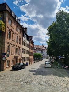 une rue pavée dans une ville avec des bâtiments dans l'établissement Altbau Charme in der Nürnberger Innenstadt, à Nuremberg