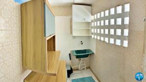 a small bathroom with a sink and a window at Vacanze - Jardim Tropical in Maceió