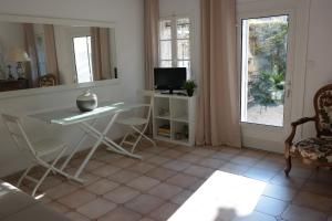 een woonkamer met een witte tafel en een raam bij Arles les Alyscamps in Arles