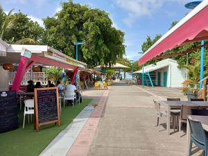 a street with tables and chairs and people sitting at tables at Blue Side in Le Moule