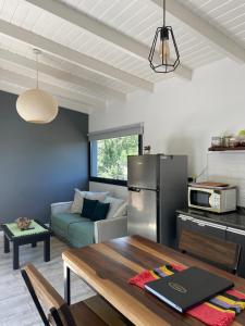 a kitchen and living room with a table and a refrigerator at Cabaña Panpachay Villa Giardino in Villa Giardino