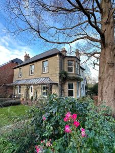 una casa grande con flores rosas delante en 30 Park Street, en Hungerford