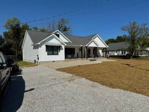 a white house with a driveway in front of it at Beck Lake House in Kelleys Island