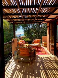 a patio with a wooden pergola and a table at San Marco Luxury Tuscan Beachside Villa in Whangamata