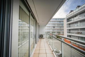 an empty corridor in a building with glass windows at Apartamento Lux 1882 in Figueira da Foz