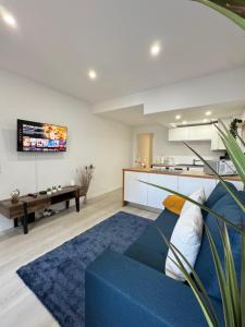 a living room with a blue couch and a kitchen at Apartamento em Cascais in Cascais