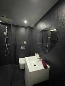 a bathroom with a sink and a shower and a mirror at Apartamento em Cascais in Cascais