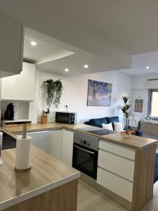 a kitchen with white cabinets and a stove top oven at Apartamento em Cascais in Cascais