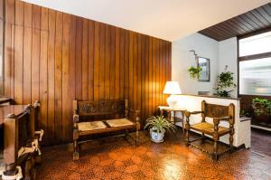 Habitación con paredes de madera, 2 sillas y mesa. en Hotel Urca en Mar del Plata