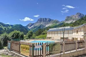 een resort met een zwembad en bergen op de achtergrond bij Le Courchevel à Grèsse in Gresse-en-Vercors