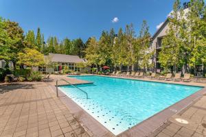 Una gran piscina con sillas y una casa. en Spacious 2bedroom 2bath Nike Headquarters, en Beaverton