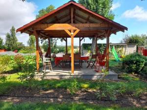 a wooden gazebo with a table and chairs at L'Orée du bois Narcy in Narcy +29 photos