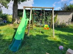 a playground with a slide and a swing at L'Orée du bois Narcy in Narcy