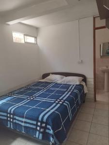 a bedroom with a bed with a blue and white blanket at Hostal Venecia in Arica +41 photos