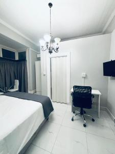 a bedroom with a bed and a chair and a chandelier at Stay-Tiah Whyte Room in Durban +4 photos