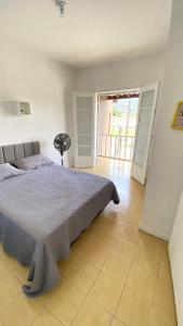 1 dormitorio con 1 cama y puerta a un balcón en Quarto em Martim de Sá, en Caraguatatuba