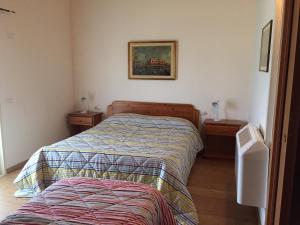 TrichianaにあるAffittacamere Dormire Caldiのベッドルーム1室(ベッド1台、ナイトスタンド2台付)