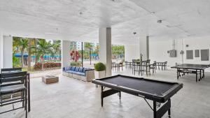 einen Billardtisch in einem Zimmer mit Tischen und Stühlen in der Unterkunft Absolute Beach Bliss, Chic & Expansive Retreat in Sunny Isles Beach