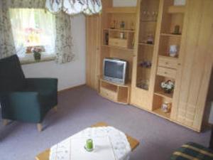 un salon avec une chaise et une télévision dans l'établissement Ferienwohnung Kahlersberg, à Schönau am Königssee
