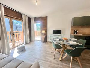 a living room with a table and chairs and a kitchen at Résidence Le Living Stone B - PARKING-PROCHE PISTES-COEUR DE STATION-Tout inclus MAE-7981 in Vars