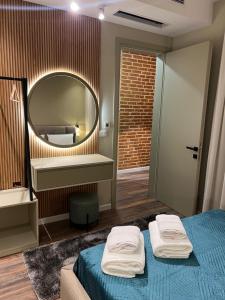 a bedroom with a mirror and a bed with towels on it at Liams Cozy Villa in Korçë