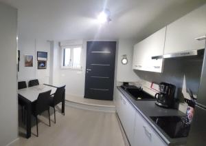 a kitchen with a table and a black door at le palierou in Paulhe