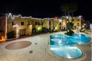 a swimming pool in front of a building at night at Grand Hotel Mosè in Villaggio Mosè