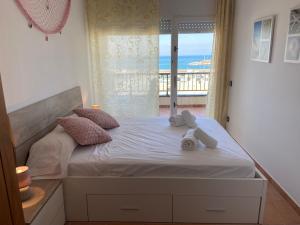 a bedroom with a bed with a view of the ocean at Ca La Ona in L'Escala