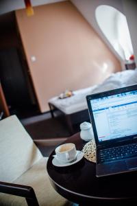 a laptop computer sitting on a table with a cup of coffee at Vanilla House in Zwoleń